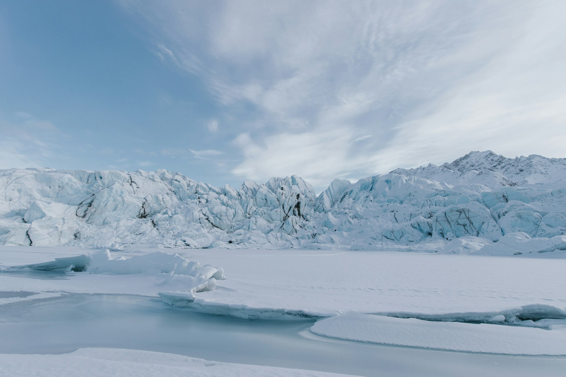 A glacier and frozen lake under an Arctic sky in Alaska.